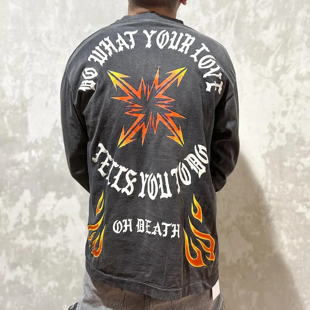 SAINT Mxxxxxx M/AFTER LS_TEE/BLACK Flame arrow Letter M retro distressed long tee Washed black S-XL Tubular fabric Assute ready-made garments dyed The whole piece is sprayed with horse-hair spray and then sprayed again to fade the color. The collar and cuffs are frayed. Many places are frayed. Extra large printing position. Very difficult to print. Complete accessories. With little angel anti-counterfeiting label.